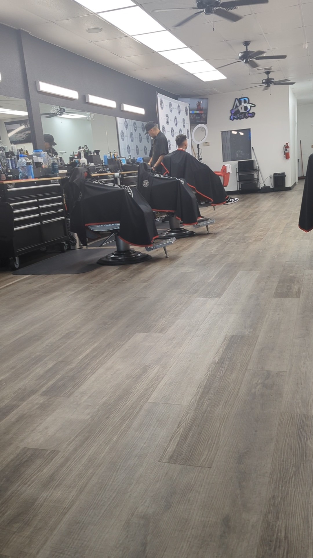 Barbers working at stations in modern shop interior